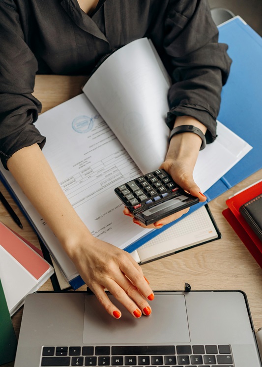 Person using laptop and calculator
