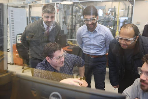 Dimitris Assanis with students in the internal combustion lab